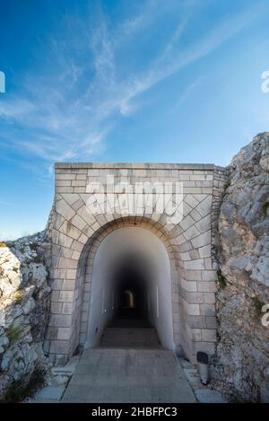 Parco Nazionale di Lovcen. Ripidi gradini di pietra bianca e scarsamente illuminati che conducono in un lungo tunnel stretto nella montagna dal Mausoleo di Petar II Petrovic-Njeg Foto Stock