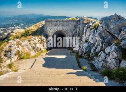 Parco Nazionale di Lovcen. Ripidi gradini di pietra bianca e scarsamente illuminati che conducono in un lungo tunnel stretto nella montagna dal Mausoleo di Petar II Petrovic-Njeg Foto Stock