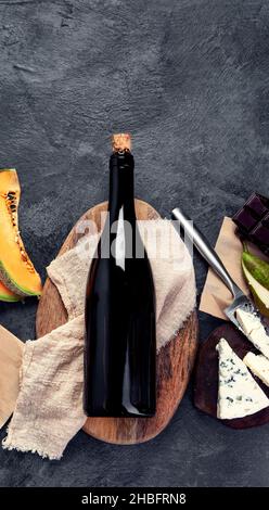 Vino rosso con antipasti su sfondo grigio. Bevande alcoliche tradizionali. Vista dall'alto, disposizione piatta, spazio di copia Foto Stock