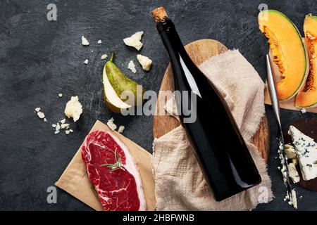 Vino rosso con antipasti su sfondo grigio. Bevande alcoliche tradizionali. Vista dall'alto, disposizione piatta, spazio di copia Foto Stock