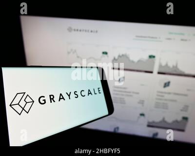 Cellulare con logo della società americana Crypto Currency Company Grayscale Investments LLC sullo schermo di fronte al sito web. Mettere a fuoco sulla sinistra del display del telefono. Foto Stock