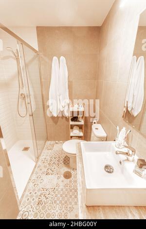 Bagno con doccia, wc e lavandino con specchio dall'hotel Foto Stock