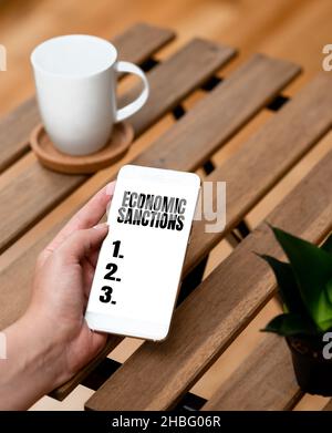 Testo della scrittura sanzioni economiche. Concetto che significa pena punizione imposta su un altro paese guerra commerciale voce e video capacità di chiamata Foto Stock