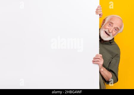 Foto di impressa anziano grigio hairdo uomo look fotocamera indossare abiti cachi isolato su sfondo giallo Foto Stock