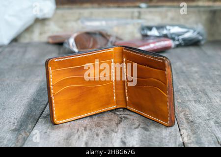 Denaro bifold in pelle nera e portafoglio di carte di credito in lavorazione artigianato in legno Foto Stock