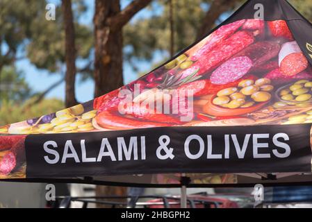 Un cartello con salumi e olive su una baldacchino all'ombra in una bancarella di mercato a Sydney, nuovo Galles del Sud, Australia Foto Stock