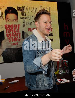 Olly Murs firma copie del suo ultimo singolo, mano su cuore, e album, giusto posto giusto tempo e incontra e saluta con i suoi fan al HMV Oxford Circus di Londra Foto Stock