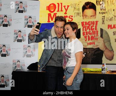 Olly Murs firma copie del suo ultimo singolo, mano su cuore, e album, giusto posto giusto tempo e incontra e saluta con i suoi fan al HMV Oxford Circus di Londra Foto Stock