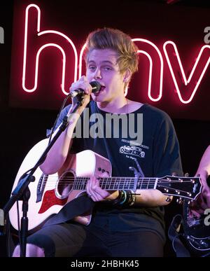 Luke Hemmings di 5 secondi d'estate suona il set acustico sul palco all'HMV Oxford Circus di Londra. Foto Stock