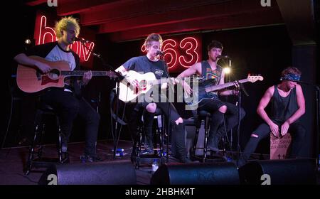 (Sinistra - destra) Michael Clifford, Luke Hemmings, Calum Hood e Ashton Irwin di 5 secondi d'estate si esibiscono sul palco acustico all'HMV Oxford Circus di Londra. Foto Stock