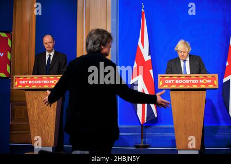 Il giornalista Robert Peston fa una domanda mentre il primo ministro britannico Boris Johnson e il Chief Medical Officer per l'Inghilterra Chris Whitty guardano sopra durante un C. Foto Stock