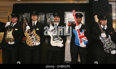 Le guardie di sicurezza ospitano le chitarre elettriche più preziose del mondo, (sinistra-destra) la firma di Rory Gallagher 1961 Fender Stratocaster, la chitarra personalizzata Keith Richards, la chitarra Jimi Hendrix degli anni '60 e la chitarra "London:Birth of a cult" personalizzata da Heidi Slimane e Johnny Rockets "Dirty Little Thing" dopo il loro arrivo ad Harrods nel centro di Londra. Foto Stock