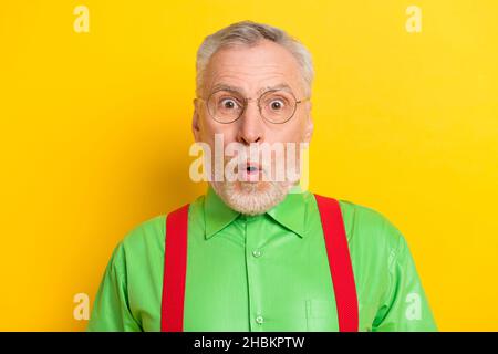 Foto ritratto uomo vecchio stupito bocca aperta in occhiali indossando vestito festivo isolato giallo brillante sfondo di colore Foto Stock