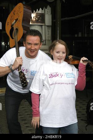 Russell Watson si pone con Lizzie Davies, 18 come egli aiuta a lanciare 'Practice-a-thon' che incoraggia le persone a suonare strumenti musicali e raccogliere soldi per i bambini con cancro, all'Hard Rock Cafe di Piccadilly, Londra. Foto Stock