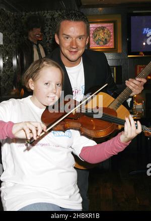 Russell Watson si pone con Lizzie Davies, 18 come egli aiuta a lanciare 'Practice-a-thon' che incoraggia le persone a suonare strumenti musicali e raccogliere soldi per i bambini con cancro, all'Hard Rock Cafe di Piccadilly, Londra. Foto Stock