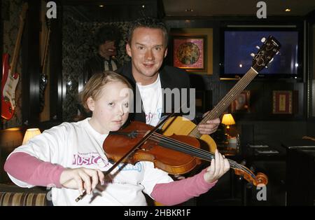 Russell Watson si pone con Lizzie Davies, 18 come egli aiuta a lanciare 'Practice-a-thon' che incoraggia le persone a suonare strumenti musicali e raccogliere soldi per i bambini con cancro, all'Hard Rock Cafe di Piccadilly, Londra. Foto Stock