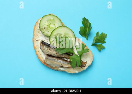 Gustoso sandwich con spratti su sfondo blu Foto Stock