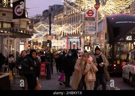 Gli amanti dello shopping natalizio si accollano le folle di Regent Street prima del giorno di Natale, mentre i casi Omicron continuano a spirale in vista delle festività natalizie. Foto Stock