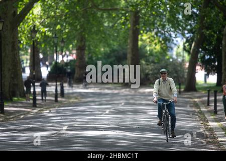 Foto del file datata 15/05/20 di un ciclista che attraversa Battersea Park, Londra, durante il blocco. Una foto è stata ottenuta dal Guardiano che mostra il primo Ministro Boris Johnson, il suo allora fidanzato Carrie, e 17 altri membri del personale nel giardino Downing Street il 15 maggio 2020, con bottiglie di vino e un cheeseboard su un tavolo di fronte al primo Ministro. Data di emissione: Lunedì 20 dicembre 2021. Foto Stock