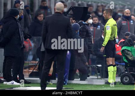 L’arbitro Davide massa controlla lo schermo VAR per valutare un gol segnato dall’AC Milan, prima di decidere di non permettere che durante la serie una partita tra AC Milan e SSC Napol allo Stadio Giuseppe Meazza il 19 dicembre 2021 a Milano. Foto Stock