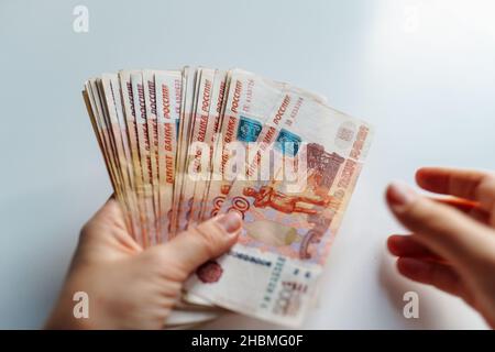 Le mani delle donne contano i soldi della carta. Banconote di cinquemila rubli russi. Vista dall'alto Foto Stock