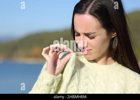 Donna disgustata che lamentava un cattivo odore di vestiti in montagna Foto Stock