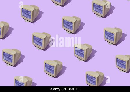 Modello di monitor di computer vintage in righe diagonali su uno sfondo viola colorato con ombra sfumata Foto Stock