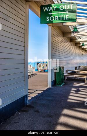 Guardando attraverso una porta nella piattaforma della stazione ferroviaria di Folkestone Harbour, con una via d'uscita, segno verde Sortie appeso sopra la porta, 13th luglio 2021 Foto Stock