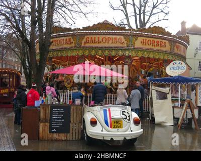 Tradizionale giro in fairground con cavalli dipinti su un merry-go-round per i bambini piccoli; feste al mercato di Natale di York, 2021 dicembre. Foto Stock