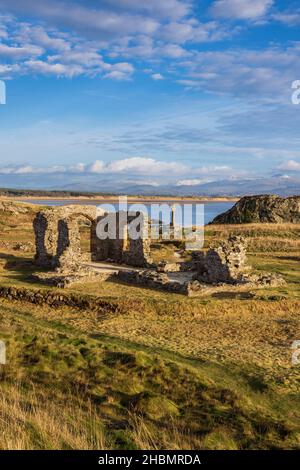 La croce celtica e le rovine della chiesa di San Dwynwen sull'isola di Llanddwyn, Isola di Anglesey, Galles del Nord Foto Stock