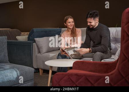 Donna sorridente e uomo che sceglie nuovi articoli di arredamento Foto Stock