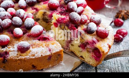 Fetta di torta di mirtilli fatta in casa con noci, bacche e zucchero in polvere sul vecchio fone di legno. Spazio per il testo. Stile rustico. Messa a fuoco selettiva. Foto Stock