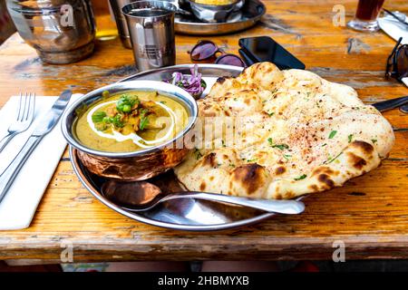 Cibo indiano - curry e pane naan in un ristorante (il Chili Pickle a Brighton, Regno Unito) Foto Stock