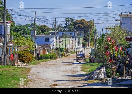 Strada sterrata che attraversa il villaggio rurale nella campagna della provincia di Villa Clara sull'isola Cuba, Caraibi Foto Stock