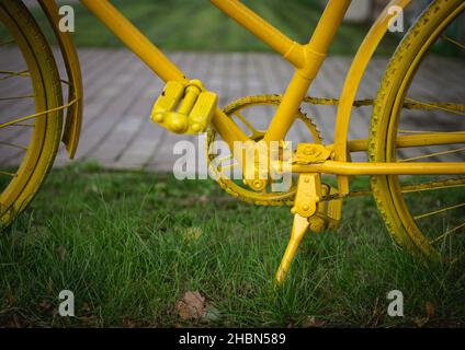 la bicicletta gialla nell'erba verde e gialla è la catena, il pignone, i pedali, il telaio, gli pneumatici, raggi, piede Foto Stock