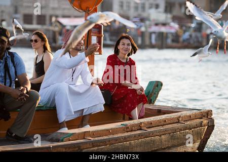 Un gruppo di turisti in sella a un'Abra attraverso il Dubai Creek negli Emirati Arabi Uniti. Foto Stock