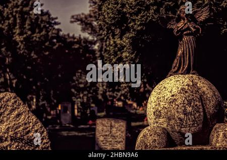 Un piccolo angelo suona musica in un cimitero Foto Stock