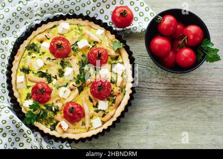 Torta di quiche con carne di pollo, pomodori, spinaci e formaggio. Foto Stock