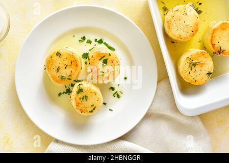 Patate fondenti su sfondo chiaro. Patate al forno nel burro e brodo di pollo. Vista dall'alto, piatto Foto Stock