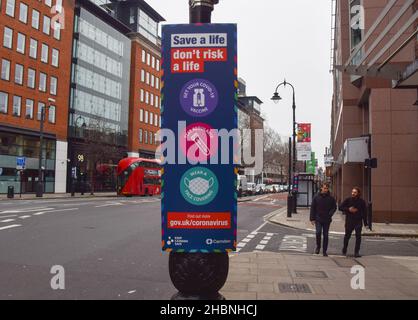 Londra, Regno Unito 18th dicembre 2021. I nuovi segni "salvare una vita, non rischiare Una vita" che spingono tutti a ottenere un vaccino, a sottoporli a test e ad indossare una maschera sono stati installati intorno al centro di Londra, in quanto la variante Omicron di COVID-19 si diffonde nel Regno Unito. Foto Stock