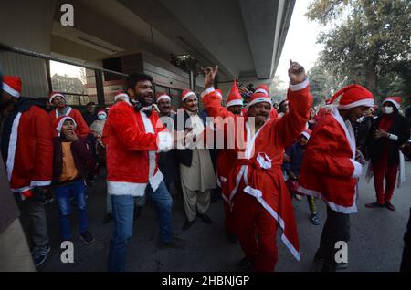 Peshawar, Pakistan. 20th Dic 2021. I membri della minoranza cristiana pakistana vestita come clausole di Santa prendono parte ad un raduno pre-Natale su una strada a Peshawar. Il Pakistan è un paese musulmano a maggioranza sunnita con quattro milioni di cristiani su una popolazione totale di circa 200 milioni di abitanti. (Foto di Hussain Ali/Pacific Press) Credit: Pacific Press Media Production Corp./Alamy Live News Foto Stock