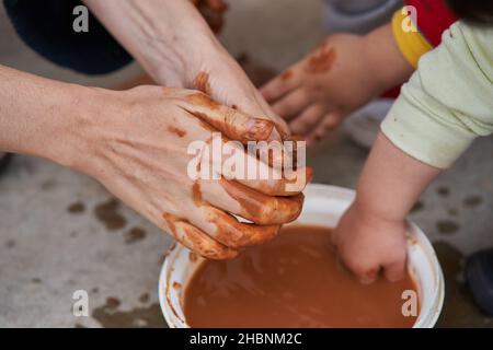 le mani della donna con i bambini che modellano l'argilla Foto Stock