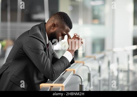 Sopraffatti uomo d'affari nero sensazione giù dopo riunione di affari Foto Stock