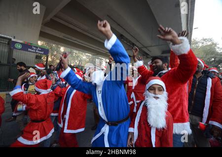 Peshawar, Peshawar, Pakistan. 20th Dic 2021. I membri della minoranza cristiana pakistana vestita come clausole di Santa prendono parte ad un raduno pre-Natale su una strada a Peshawar. Il Pakistan è un paese musulmano a maggioranza sunnita con quattro milioni di cristiani su una popolazione totale di circa 200 milioni di abitanti. (Credit Image: © Hussain Ali/Pacific Press via ZUMA Press Wire) Foto Stock