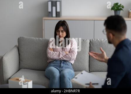 Assistenza psicologica, trattamento e sostegno. Signora araba che soffre di depressione, ascoltando i consigli dello psicologo Foto Stock