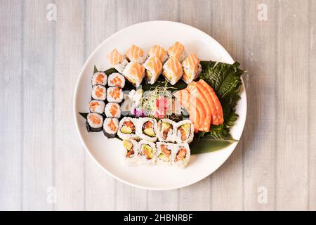 Il sushi è un piatto tipico di origine giapponese a base di riso condito con aceto di riso, zucchero e sale e combinato con altri ingredienti come il fi crudo Foto Stock