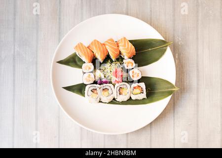 Il sushi è un piatto tipico di origine giapponese a base di riso condito con aceto di riso, zucchero e sale e combinato con altri ingredienti come il fi crudo Foto Stock