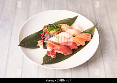 Il sushi è un piatto tipico di origine giapponese a base di riso condito con aceto di riso, zucchero e sale e combinato con altri ingredienti come il fi crudo Foto Stock