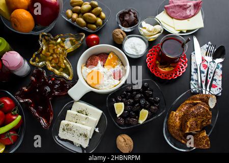 Colazione tradizionale turca sulla superficie nera. Salsiccia e uova al centro della cornice. Vista dall'alto. Foto Stock