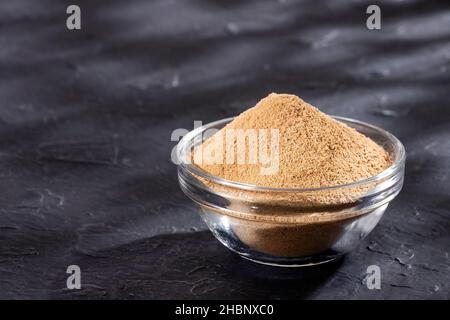 Polvere organica di radice di maca in ciotola di legno - Lepidium meyenii Foto Stock